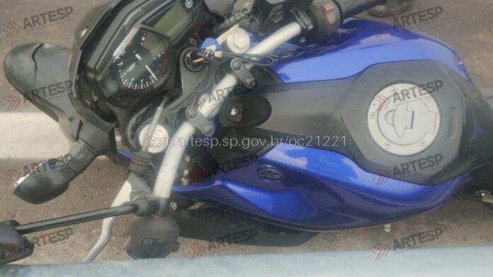 Motocicleta azul estacionada na calçada.